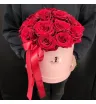 красные розы в круглой розовой шляпной коробке