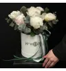 7 белых пионов с эвкалиптом в шляпной коробке