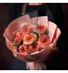 букет из персиково-оранжевых садовых роз сорта Мандарин с ваксфлауэром в светлой упаковке