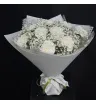 белые гвоздики и белая гипсофила в белой упаковке