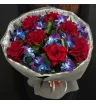 букет из красных французских роз и сине-фиолетовых орхидей с декоративной зеленью в упаковке
