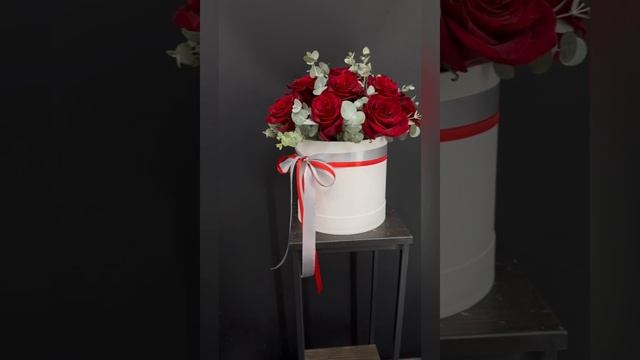 белая шляпная коробка с красными розами и эвкалиптом
