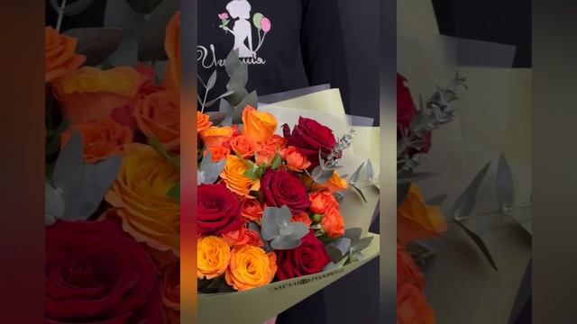 букет из красных и оранжевых роз с эвкалиптом.